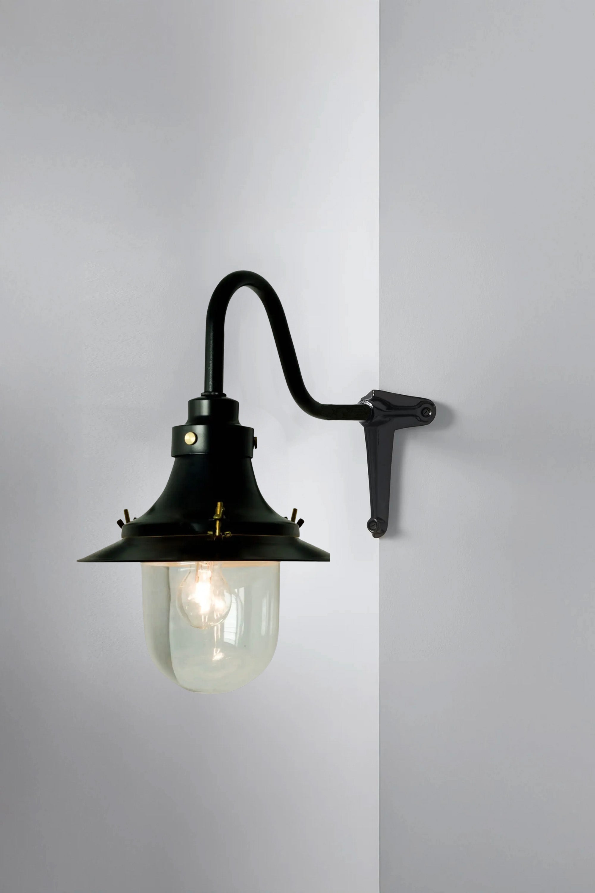 Black wall-mounted lamp with a glass shade on a gray background