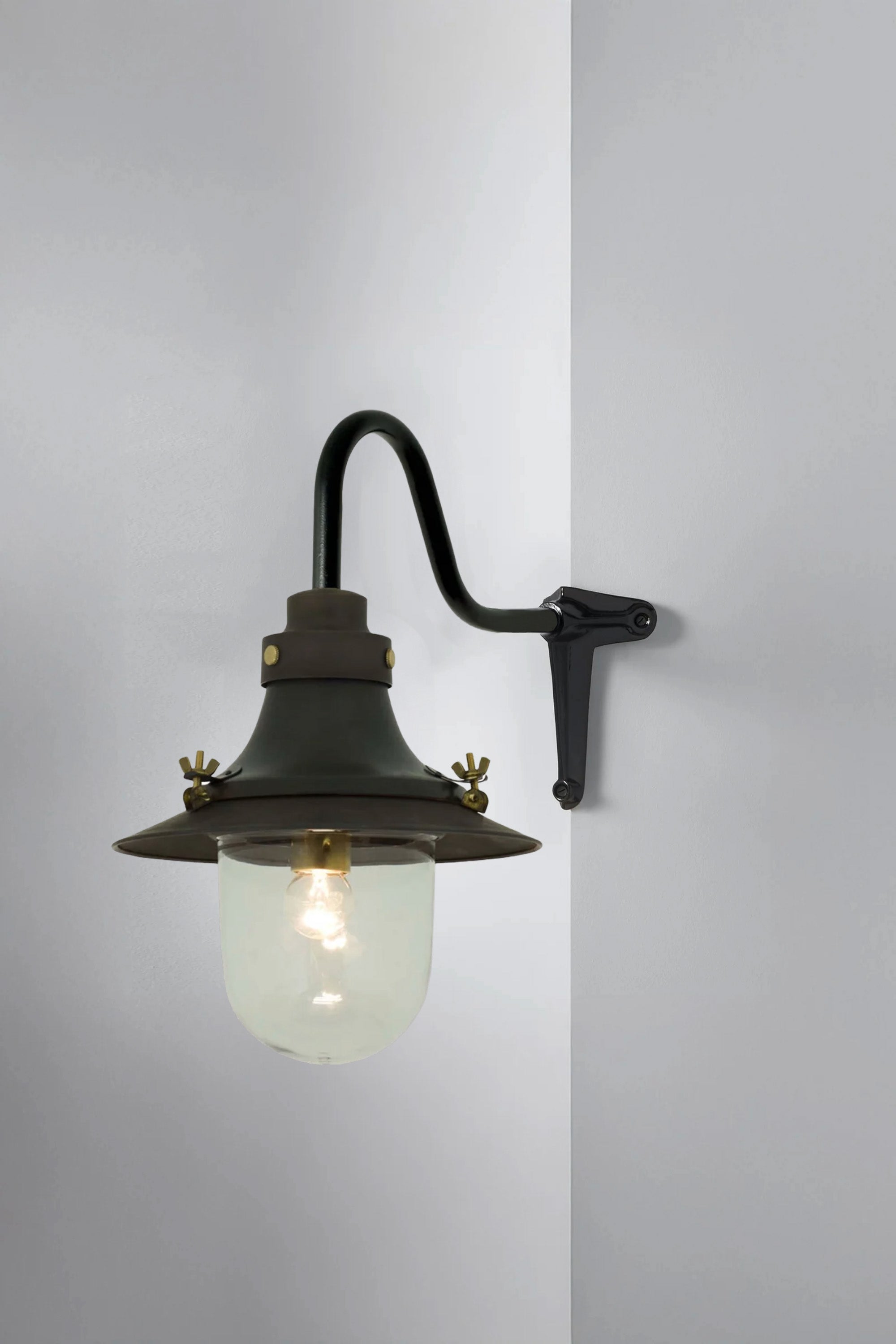 Vintage-style wall-mounted light fixture with a glass shade on a gray background