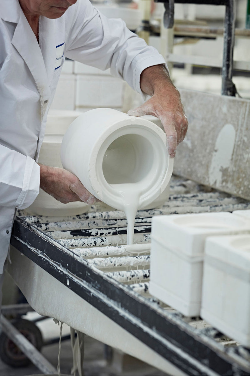 Pouring slip into moulds to create bone china lighting pieces.