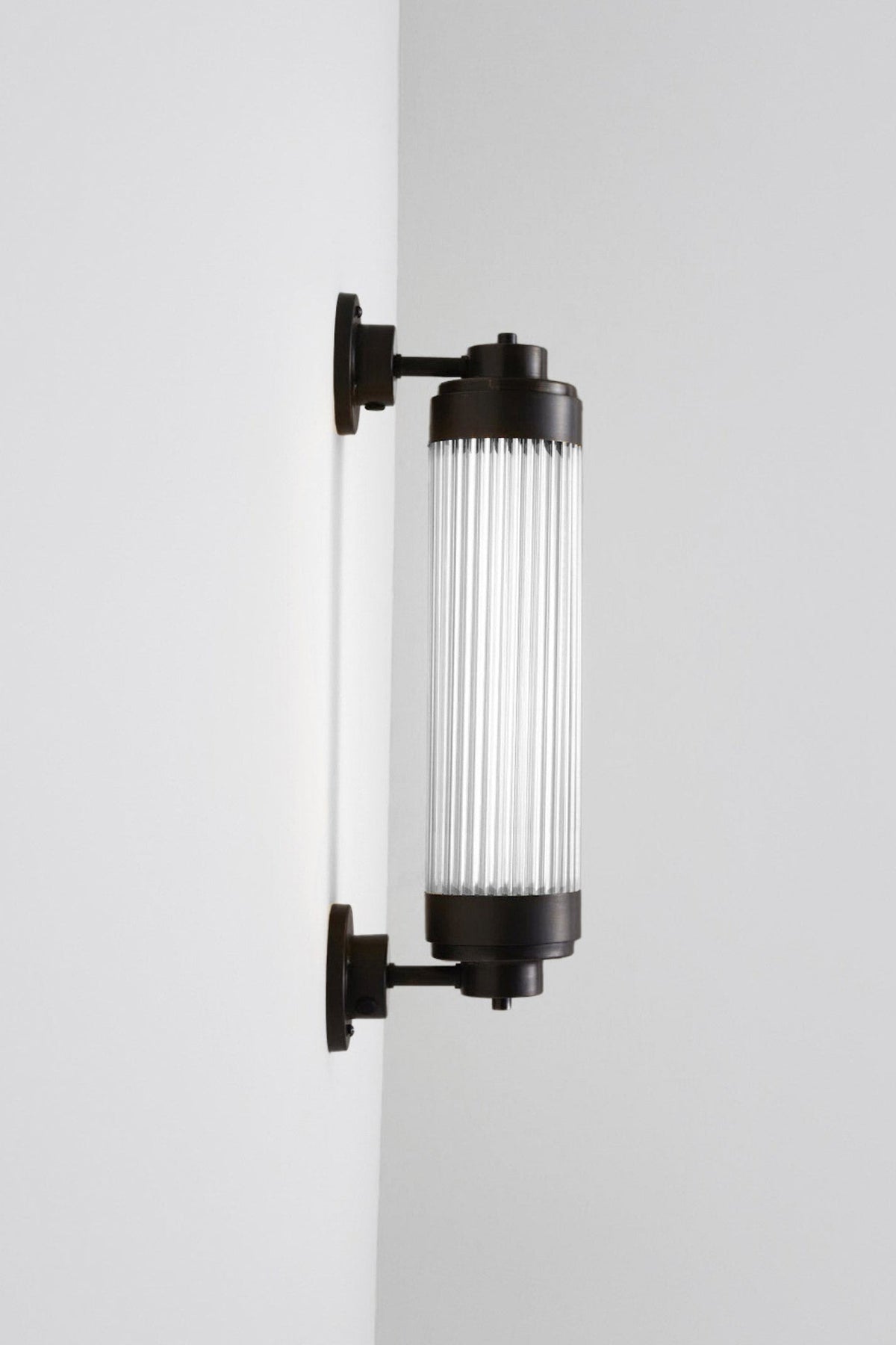 Wall-mounted cylindrical light fixture on a white background