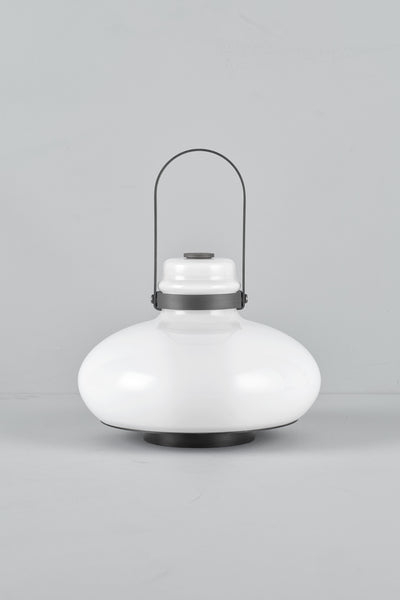 A modern white dome-shaped table lamp with a black metal handle and base, photographed against a neutral light gray background.