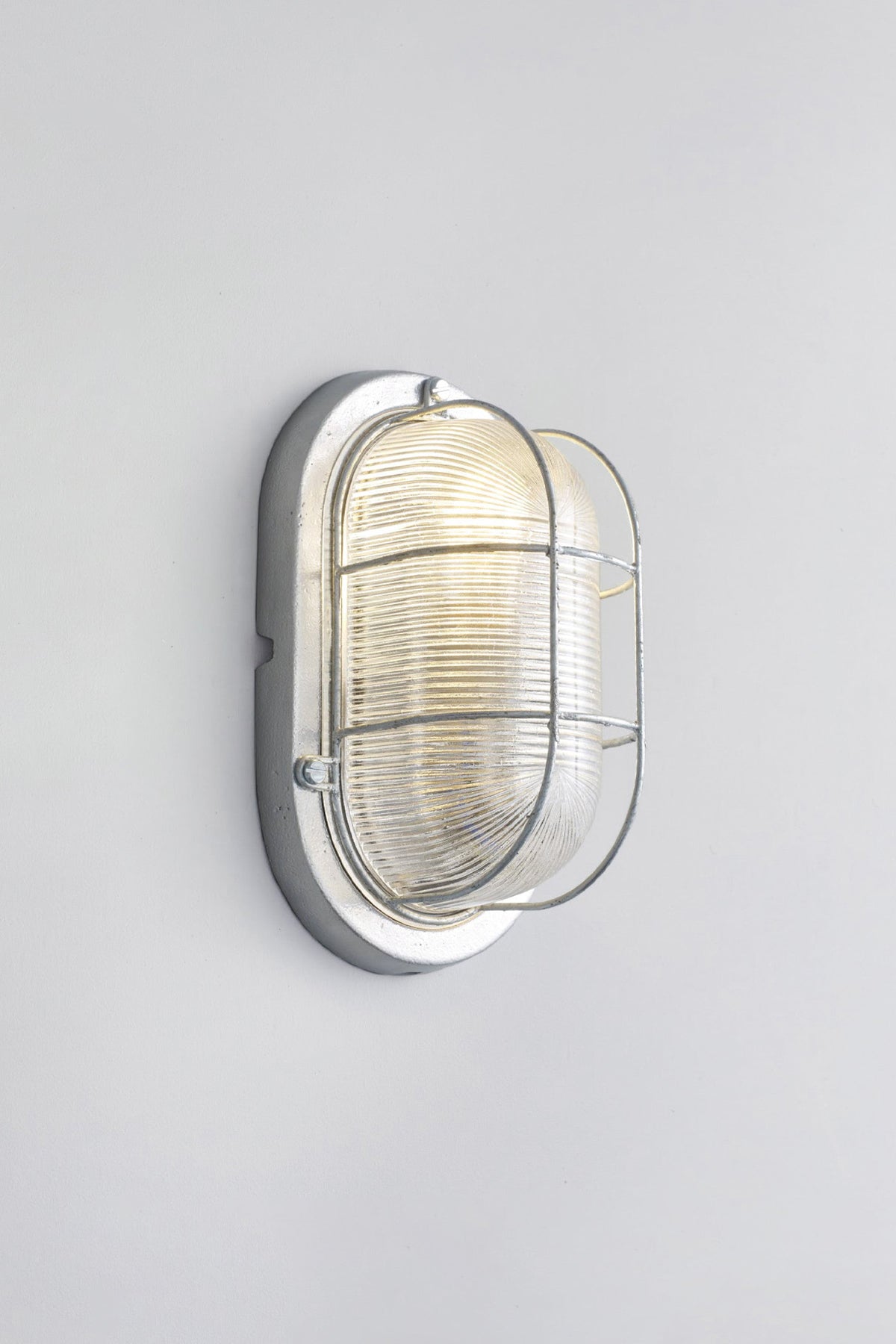 OBTC Product Image, Light On: Oval Aluminium Bulkhead for GLS 7003, Silver, Prismatic Glass, Davey Lighting Range