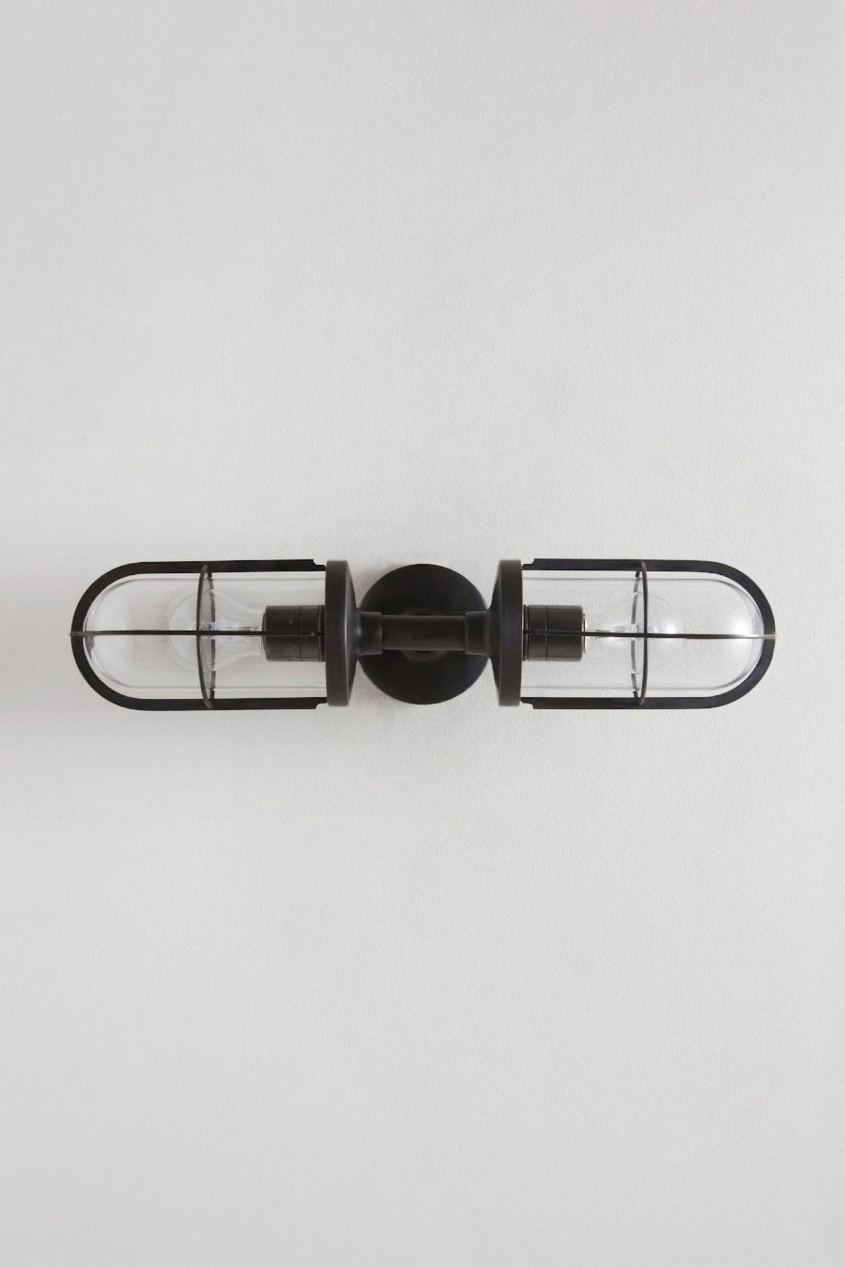 Weatherproof Ship's Double Well Glass in weathered brass with clear glass, shown unlit.