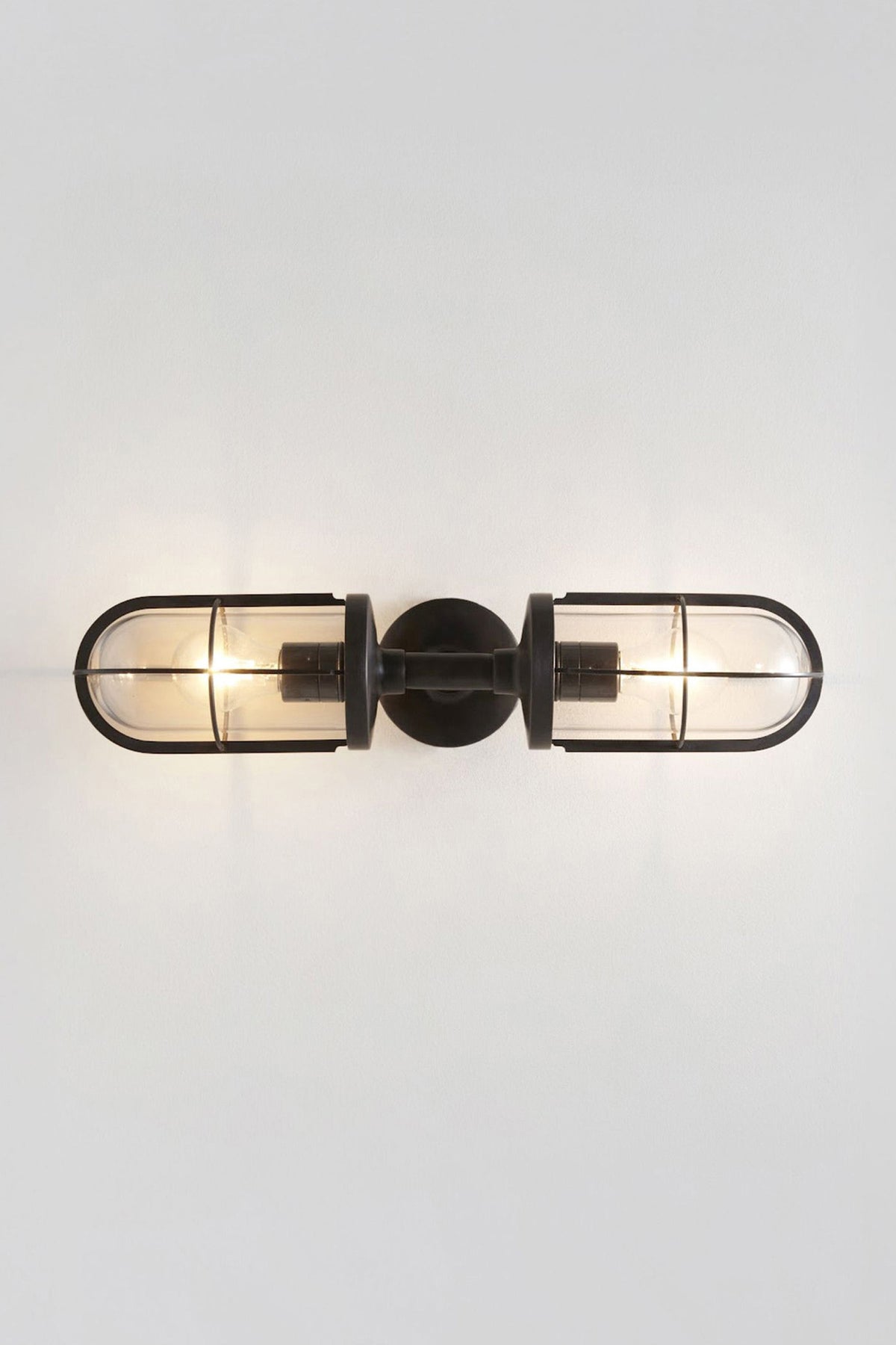 Weatherproof Ship's Double Well Glass in weathered brass with clear glass, illuminated.