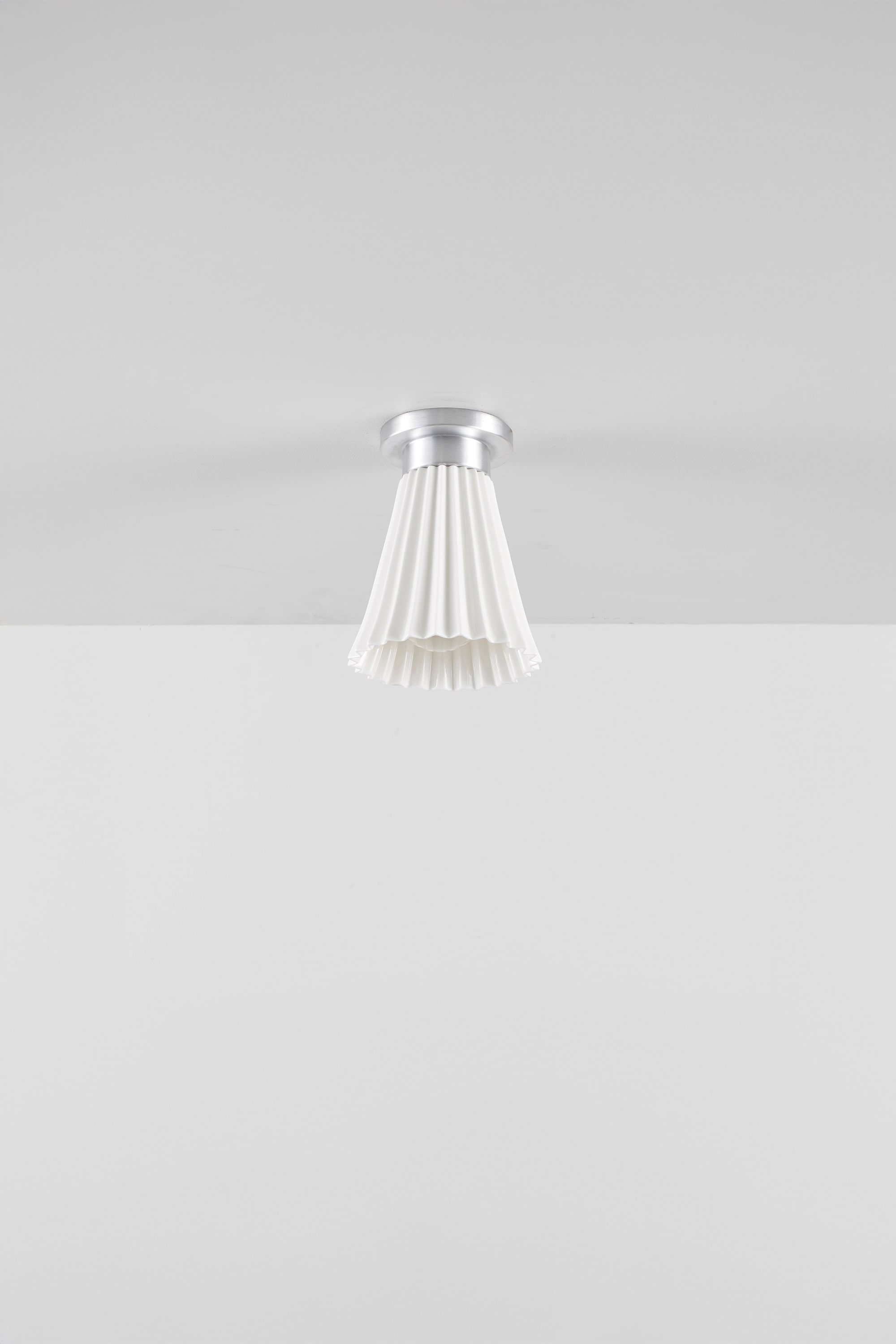 Hector Pleat medium ceiling light with a bone china shade and aluminium fittings, shown unlit.