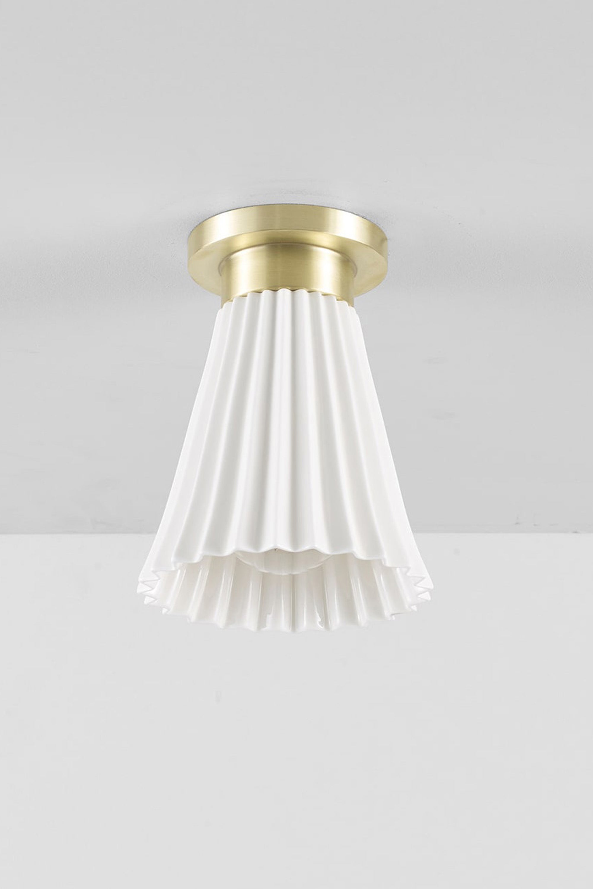 Hector Pleat medium ceiling light with a bone china shade and satin brass fittings, shown unlit.
