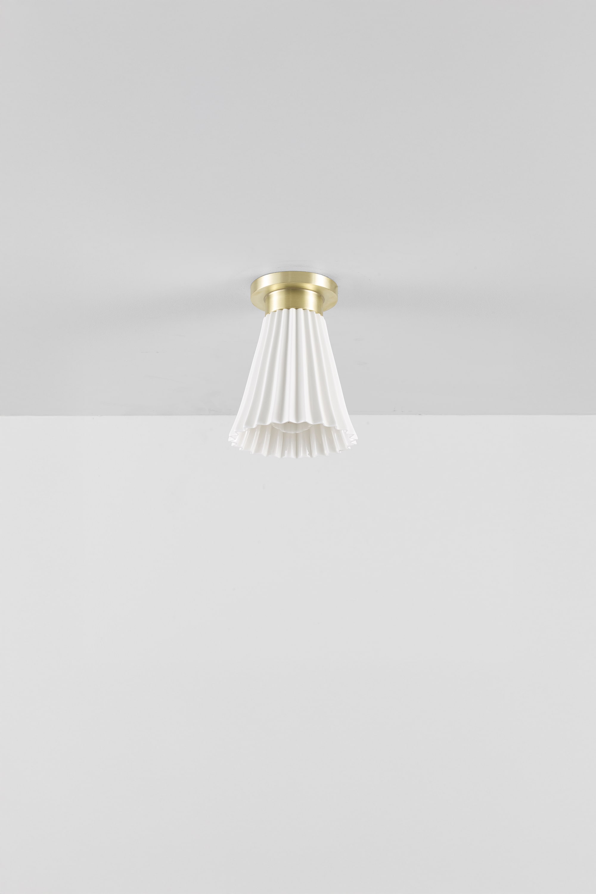Hector Pleat medium ceiling light with a bone china shade and satin brass fittings, shown unlit.