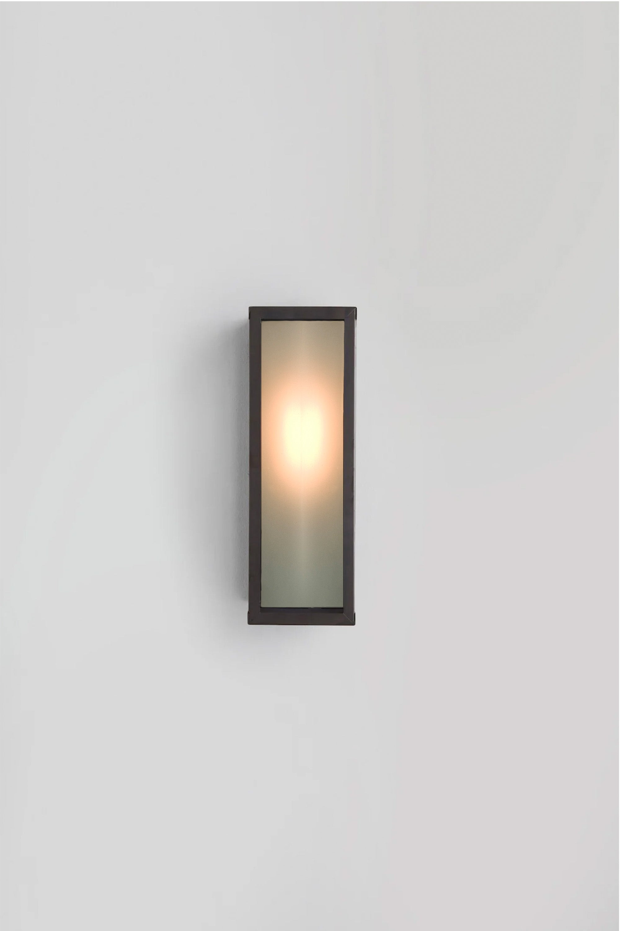 Wall-mounted light fixture with frosted glass on a plain background
